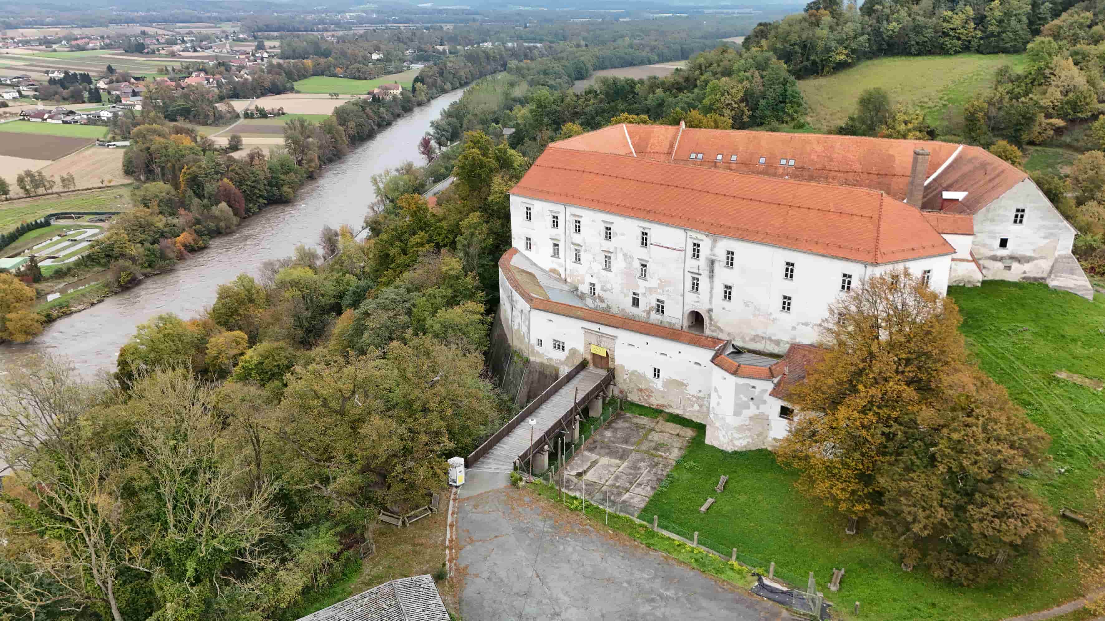 A drone image of Cmurek Castle with the Mura River on the left.